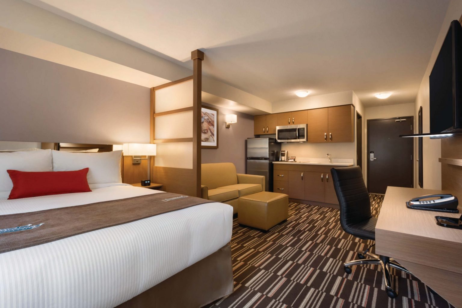 A hotel room with a kitchenette
