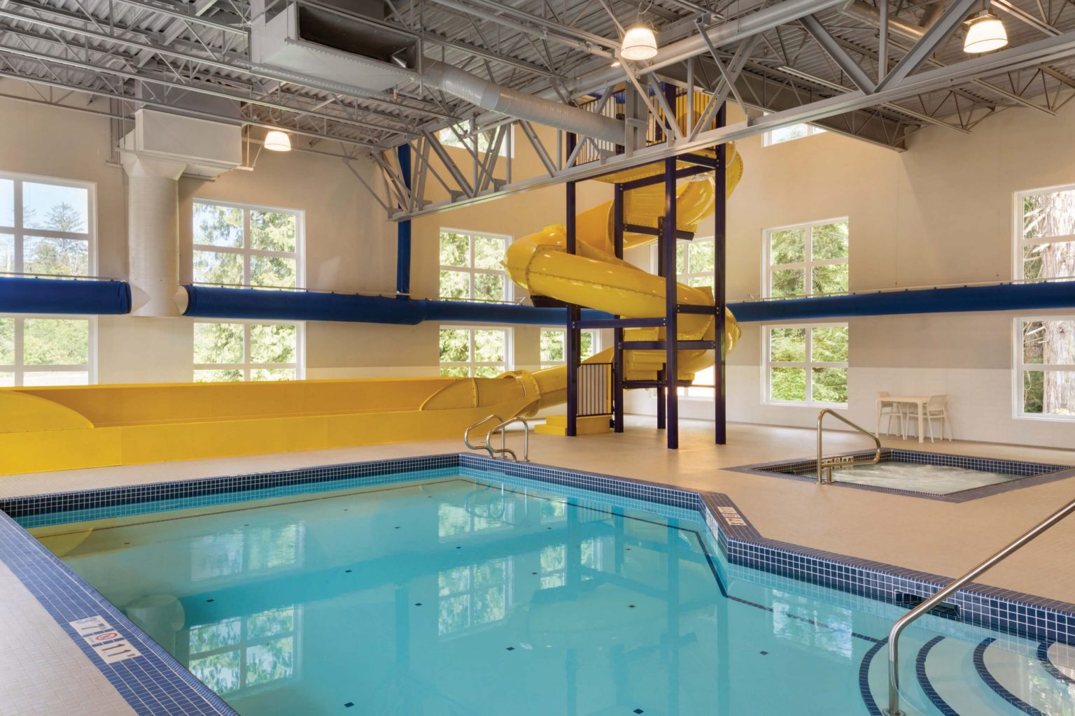 An indoor pool with a large waterslide