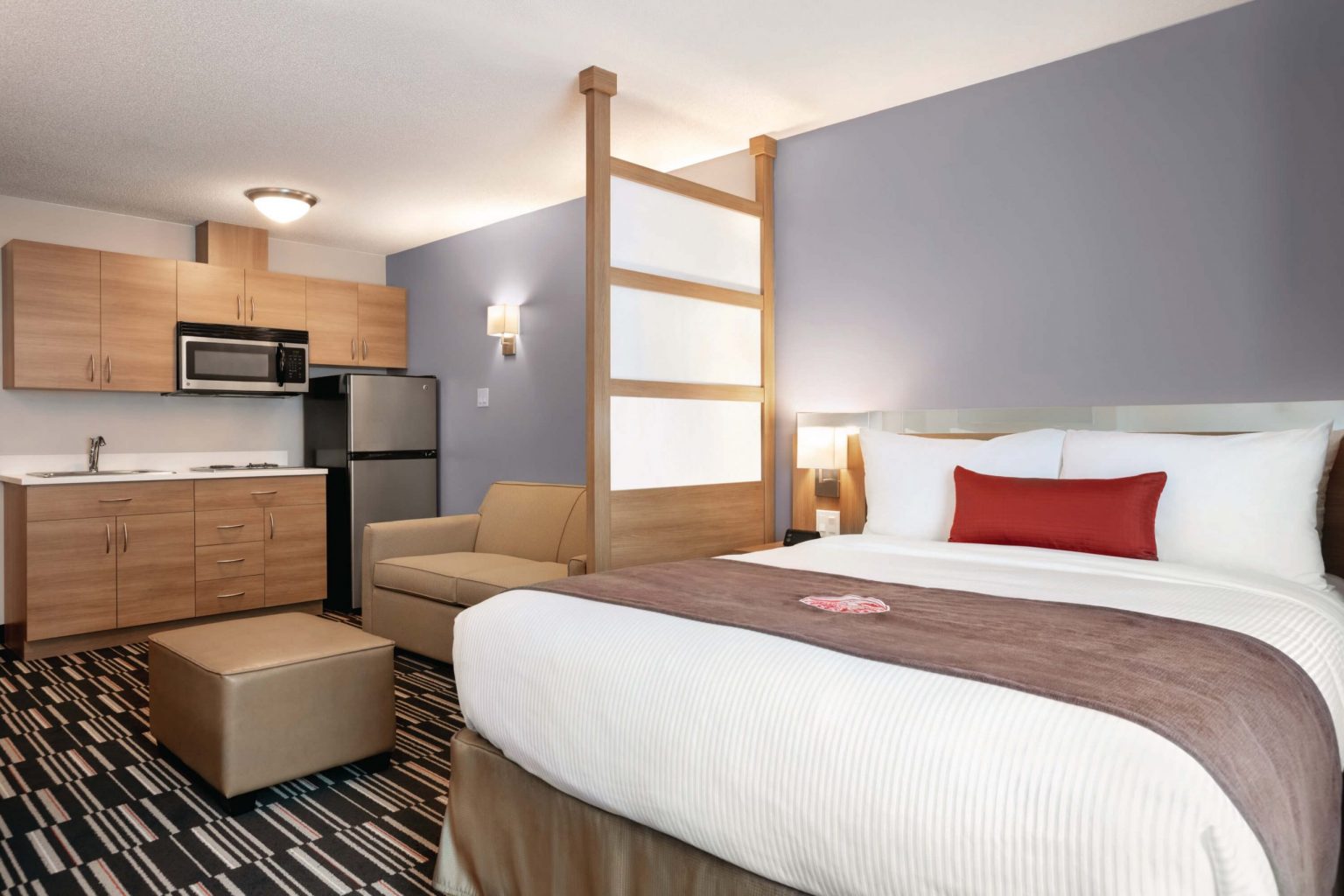 A hotel room with a kitchenette