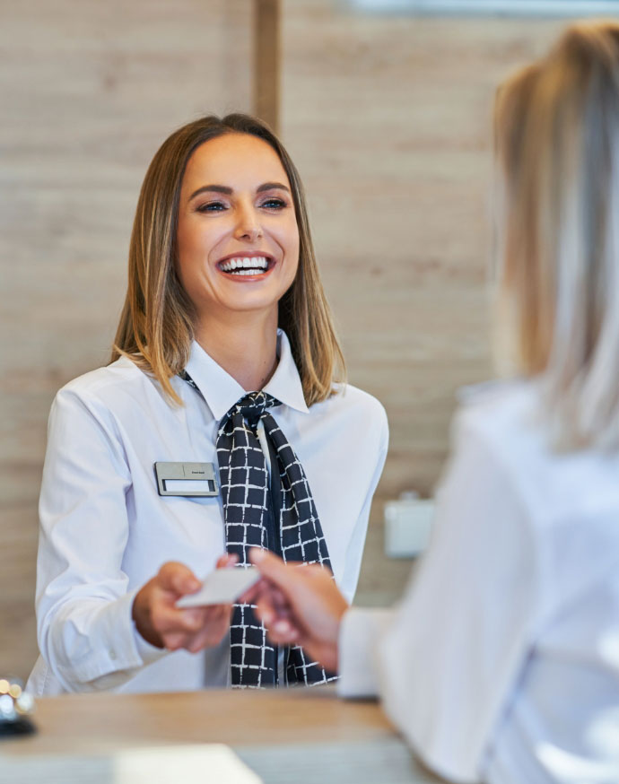 smile A smiling desk agent handing a guest her keys